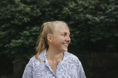 Smiling blonde woman standing outdoors