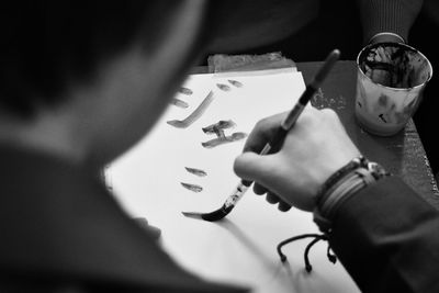 High angle view of people with hands on table