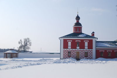 House on snow covered field against sky