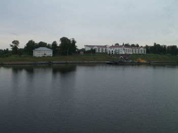 Scenic view of lake by buildings against sky