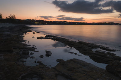 Scenic view of lake against sky at sunset