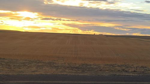 Scenic view of field against sky at sunset