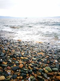 Pebbles on beach against sky