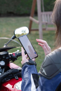 Biker girl on a motorcycle enjoys a navigator in a mobile phone