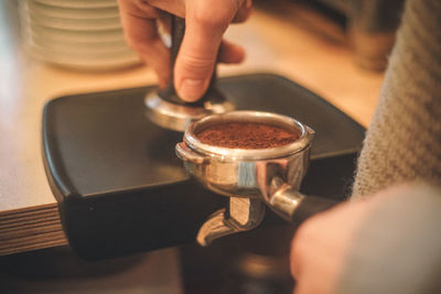 Cropped hands preparing coffee at table