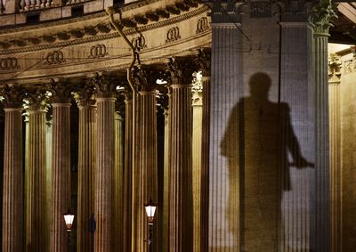 Rear view of man standing in illuminated building