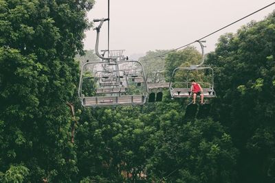 High angle view of overhead cable car amidst trees against sky