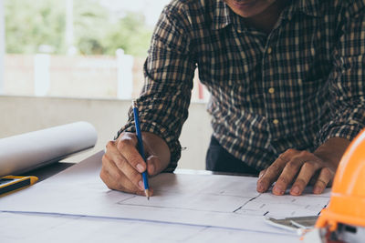 Midsection of man working on table