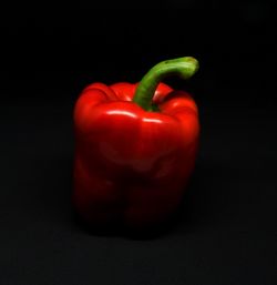 Close-up of red bell peppers against black background