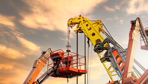 Low angle view of crane against sky during sunset