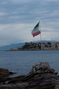 Italian flag at beach against sky