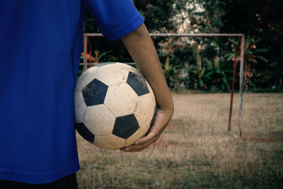 Midsection of man holding soccer ball