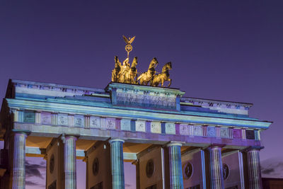 Statue in city at night