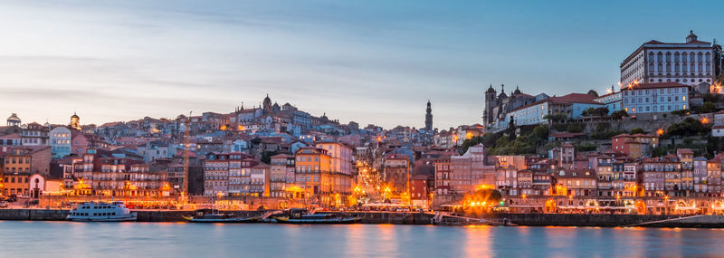 Illuminated buildings in city at dusk