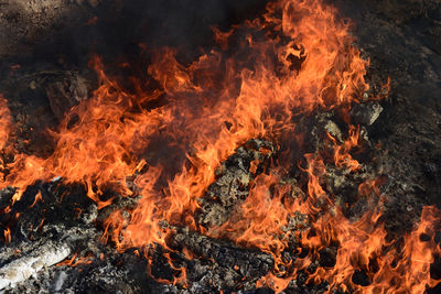 Close-up view of fire with black smoke due to burning garbage