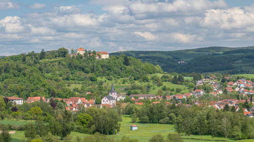 Trees and townscape against sky