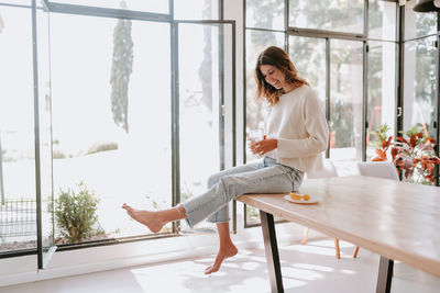 Woman sitting by window