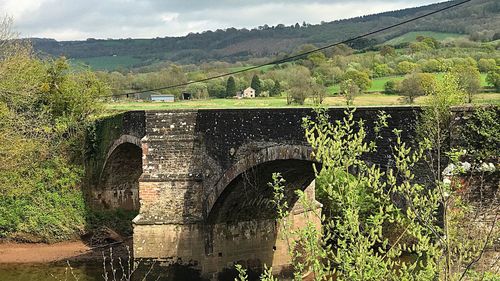 Arch bridge over river against sky