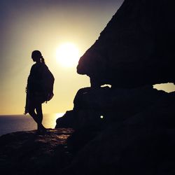 Side view of silhouette woman overlooking calm sea