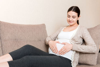 Young pregnant woman holds wooden heart. love concept.