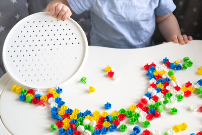 Little child playing with mushroom nail mosaic constructor.