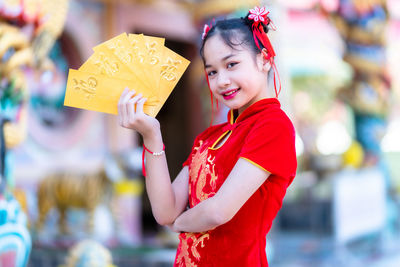 Portrait of smiling girl holding envelopes