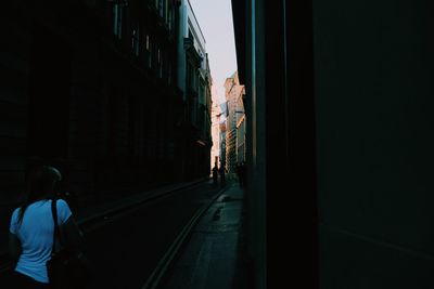 Rear view of man on railroad tracks in city