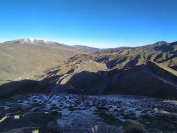 Scenic view of snowcapped mountains against clear blue sky