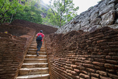 Woman climbing up the stairs towards the rock fortress of sigiriya