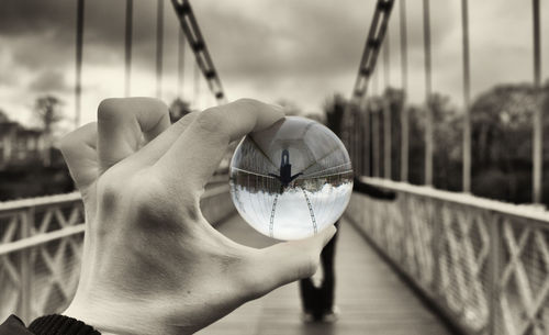 Close-up of hand holding umbrella against sky