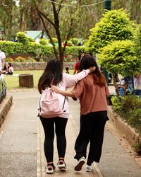 Rear view of couple standing against trees