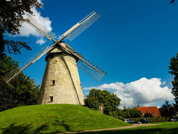 Low angle view of traditional windmill against sky