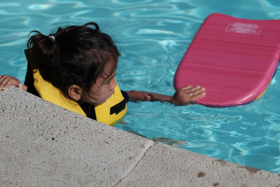 Girl with swimming board in pool