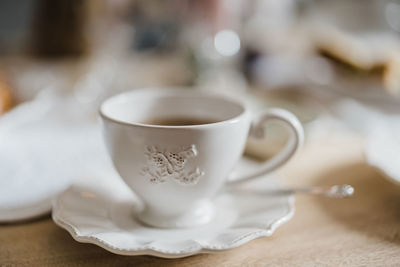 Hot cup of steaming tea in a french style cup and saucer.  neutral colours.