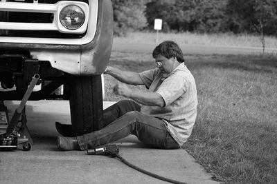 Side view of man changing tire