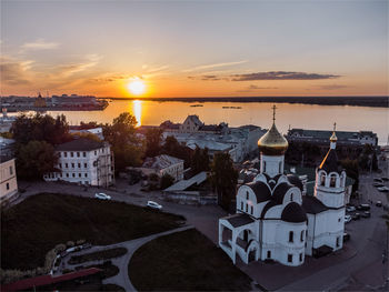 Panoramic view of sea and buildings against sky during sunset