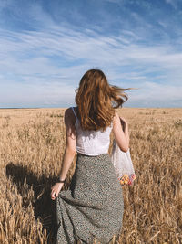 Woman standing on field against sky