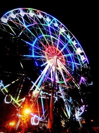 Low angle view of illuminated ferris wheel at night