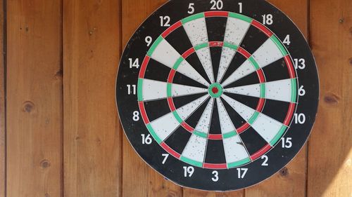 Close-up of dartboard mounted on wooden wall