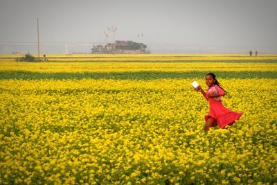 Woman with yellow flowers in field