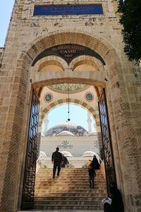 People walking on archway of historic building