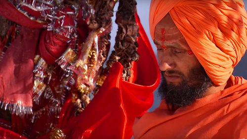 Hindu priest standing near religious offerings