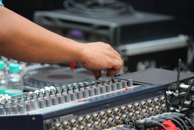 Cropped hand of man mixing sound at studio