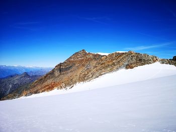 Scenic view of snowcapped mountains against clear blue sky