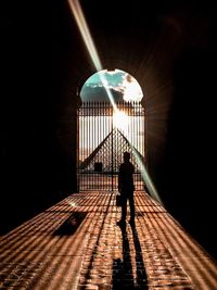 Full length of man walking in illuminated corridor