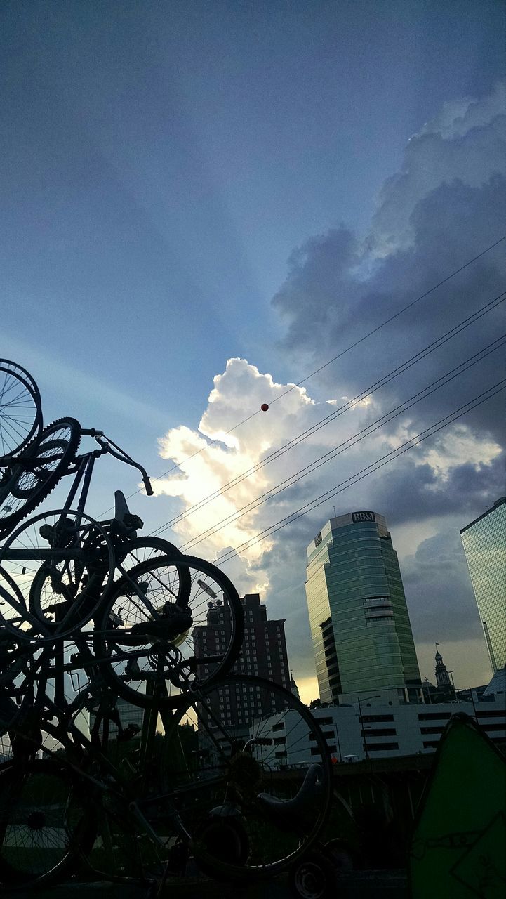 low angle view, building exterior, sky, built structure, architecture, silhouette, city, cloud - sky, building, outdoors, no people, day, tree, cloud, tall - high, modern, blue, nature, flying, sunlight