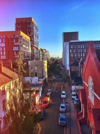 Vehicles on road in city against clear sky