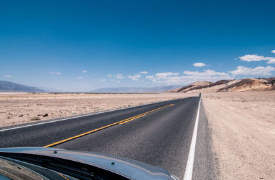 Road passing through landscape against sky