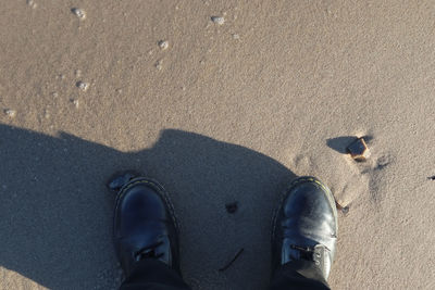 Low section of person standing on sand