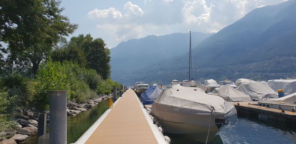 Panoramic view of boats moored in lake against sky